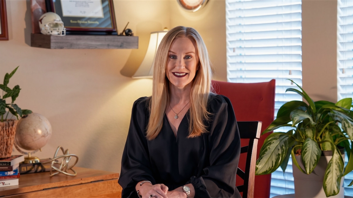 Melissa Aarskaug smiling in a home office with plants and a globe