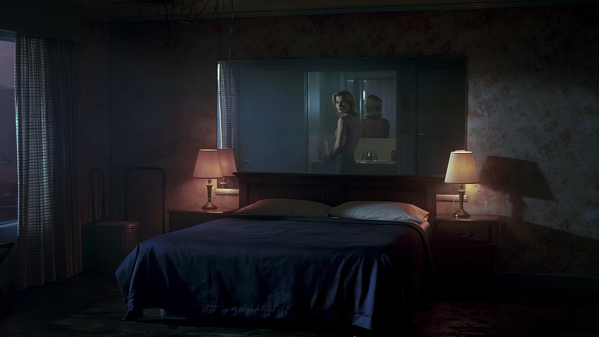 Composición fotográfica en habitación oscura con cuadro iluminado sobre la cama